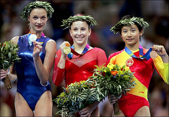 Carly Patterson of the United States, center, holds her gold medal, Svetlana Khorkina of Russia, left, holds her silver medal and Zhang Nan of China holds her bronze medal after the women's gymnastics individual all-around final at the 2004 Summer Olympic Games, Athens, August 19, 2004.